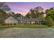 Inviting single-story home featuring a cozy front porch, well-maintained lawn, and mature landscaping at 6585 Queen Mill Se Rd, Mableton, GA 30126