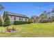 Beautiful exterior features a gray home, manicured hedges, and a vintage farm equipment display at 6585 Queen Mill Se Rd, Mableton, GA 30126