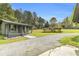 Exterior home view of a charming porch, beautiful yard, and lengthy driveway at 6585 Queen Mill Se Rd, Mableton, GA 30126