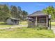 Exterior view of a gazebo, home, and adjacent gray outbuilding; lush green grass at 6585 Queen Mill Se Rd, Mableton, GA 30126