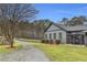 Beautiful home exterior with lush greenery, pond, and outdoor seating at 6585 Queen Mill Se Rd, Mableton, GA 30126