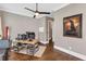 This home office has wood floors, a ceiling fan, and a large desk with multiple monitors at 6585 Queen Mill Se Rd, Mableton, GA 30126