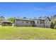 Gray home with a rear gazebo and a well-maintained lawn, showcasing the backyard and outdoor living space at 6585 Queen Mill Se Rd, Mableton, GA 30126