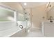 Bright bathroom featuring a soaking tub, glass shower, and double vanity with modern fixtures and neutral color palette at 122 Crestmont Dr, Canton, GA 30114