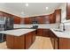 A modern kitchen with stainless steel appliances, an island, cherry wood cabinets, and light-colored hardwood flooring at 122 Crestmont Dr, Canton, GA 30114