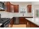 This kitchen features stainless steel appliances, an island, cherry wood cabinets, white countertops and light-colored hardwood floors at 122 Crestmont Dr, Canton, GA 30114