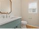 Charming powder room featuring a decorative mirror, quartz countertop, and modern fixtures at 122 Crestmont Dr, Canton, GA 30114