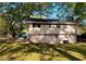 View of the back of the home showing the lawn and door, surrounded by mature trees at 1464 Colony East Cir, Stone Mountain, GA 30083