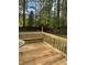 Backyard deck with wooden bench, railings, and a lush green backdrop at 230 Blue Heron Dr, Jonesboro, GA 30238