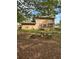 Home's backyard with stone furniture, lush green grass, patio, and a deck at 230 Blue Heron Dr, Jonesboro, GA 30238