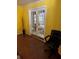 Room featuring yellow walls, wood floors, and a pair of white French doors at 230 Blue Heron Dr, Jonesboro, GA 30238
