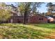 View of the brick house from the backyard with a tall shade tree at 2442 Wentworth Ne Dr, Atlanta, GA 30345