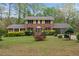 Charming two-story brick home featuring a well-manicured front yard, attached carport, and mature trees at 4606 Greensprings Rd, College Park, GA 30337