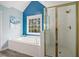 Bright bathroom featuring a soaking tub under a window and a separate glass-enclosed shower at 5296 Camden Lake Nw Pkwy, Acworth, GA 30101