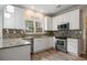 Modern kitchen featuring white cabinets, granite countertops, stainless steel appliances, and wood flooring at 5296 Camden Lake Nw Pkwy, Acworth, GA 30101