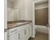 Bathroom featuring granite countertop, white cabinets, and shower/tub combo at 828 Canterbury Overlook Ne, Atlanta, GA 30324