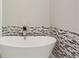 Close-up of a luxurious white bathtub with a decorative tile backsplash at 828 Canterbury Overlook Ne, Atlanta, GA 30324