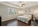 Comfortable bedroom with hardwood floors, tray ceiling, ceiling fan, and a large window at 828 Canterbury Overlook Ne, Atlanta, GA 30324
