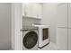 Modern laundry room with white cabinetry, stainless steel washer and dryer at 828 Canterbury Overlook Ne, Atlanta, GA 30324