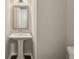Elegant powder room featuring a classic pedestal sink with modern fixtures and a framed mirror at 828 Canterbury Overlook Ne, Atlanta, GA 30324