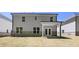 Backyard of a two-story home with brick foundation, manicured lawn and covered patio at 13918 Homer Ln, Covington, GA 30014