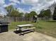 Backyard patio with barbecue grill and picnic table next to a large green lawn with a playground set at 140 Grayview Ct, Grayson, GA 30017