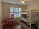 Bedroom with bunk bed, dollhouse, window with blinds, hardwood floors, offering versatile space at 140 Grayview Ct, Grayson, GA 30017