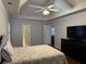 Cozy bedroom featuring tray ceilings, ceiling fan, and an adjacent bathroom for added convenience at 140 Grayview Ct, Grayson, GA 30017