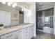 Luxurious bathroom with granite countertops, dual sinks, and a tiled walk-in shower is a spa-like retreat at 325 E Paces Ferry Ne Rd # 1405, Atlanta, GA 30305