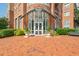 Elegant building entrance featuring a brick facade, glass doors, and manicured landscaping at 325 E Paces Ferry Ne Rd # 1405, Atlanta, GA 30305