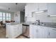 Well-lit kitchen features white cabinets, granite countertops, stainless steel appliances, and an island with barstool seating at 325 E Paces Ferry Ne Rd # 1405, Atlanta, GA 30305