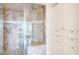 This walk-in shower boasts brown tiled walls, glass door, and adjacent built-in linen storage at 325 E Paces Ferry Ne Rd # 1405, Atlanta, GA 30305