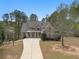 Beautifully designed brick and stone home with a long driveway and lush trees surrounding the property at 7497 Treehouse Ct, Douglasville, GA 30135