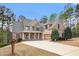 Elegant brick home featuring a manicured lawn, complemented by a spacious driveway and attached two car garage at 7497 Treehouse Ct, Douglasville, GA 30135