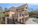 Unique exterior with covered stone veranda with outdoor ceiling fan at 7497 Treehouse Ct, Douglasville, GA 30135