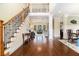Grand foyer with gleaming hardwood floors, a staircase with iron railings, and an open view to the living spaces at 7497 Treehouse Ct, Douglasville, GA 30135