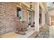 Cozy front porch features rocking chairs, charming details, and a well-maintained facade with brick and stone accents at 7497 Treehouse Ct, Douglasville, GA 30135