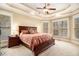 Spacious main bedroom with a tray ceiling, ceiling fan and large windows offering plenty of natural light at 7497 Treehouse Ct, Douglasville, GA 30135