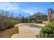 A covered pool has plenty of patio space and is surrounded by beautiful mature trees and green shrubbery at 7497 Treehouse Ct, Douglasville, GA 30135