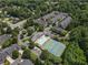 Aerial view of a community with tennis courts, a swimming pool, and mature trees around the townhomes at 2630 Milford Ln, Alpharetta, GA 30009