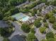 Aerial view of community tennis courts and swimming pool surrounded by townhouses and trees at 2630 Milford Ln, Alpharetta, GA 30009