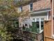 Balcony of this brick home with green plants, patio furniture, and a black and white umbrella at 2630 Milford Ln, Alpharetta, GA 30009