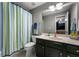 Bright bathroom with a shower featuring striped curtain, sink with vanity and plush towel at 2630 Milford Ln, Alpharetta, GA 30009