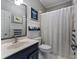 Bathroom with white and gray details, featuring a sink, toilet, and shower with a striped curtain at 2630 Milford Ln, Alpharetta, GA 30009