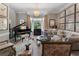 Elegant living room features a grand piano, bay window, chandelier, and stylish decor at 2630 Milford Ln, Alpharetta, GA 30009