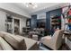 Inviting living room featuring a sofa, an armchair, and storage shelves for collectibles at 2630 Milford Ln, Alpharetta, GA 30009