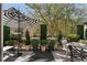 An outdoor patio area is decorated with outdoor furniture, plants, and a striped umbrella at 2630 Milford Ln, Alpharetta, GA 30009