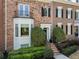 Brick townhouse with bay window, black shutters, and manicured shrubs enhancing curb appeal at 2630 Milford Ln, Alpharetta, GA 30009