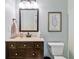 This bathroom features a dark wood vanity, beige countertops, framed mirror, and framed print at 5775 Stephens Mill Dr, Sugar Hill, GA 30518