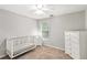 Cozy bedroom with a white crib, dresser, and natural light, perfect for a Bedroom or room at 5775 Stephens Mill Dr, Sugar Hill, GA 30518